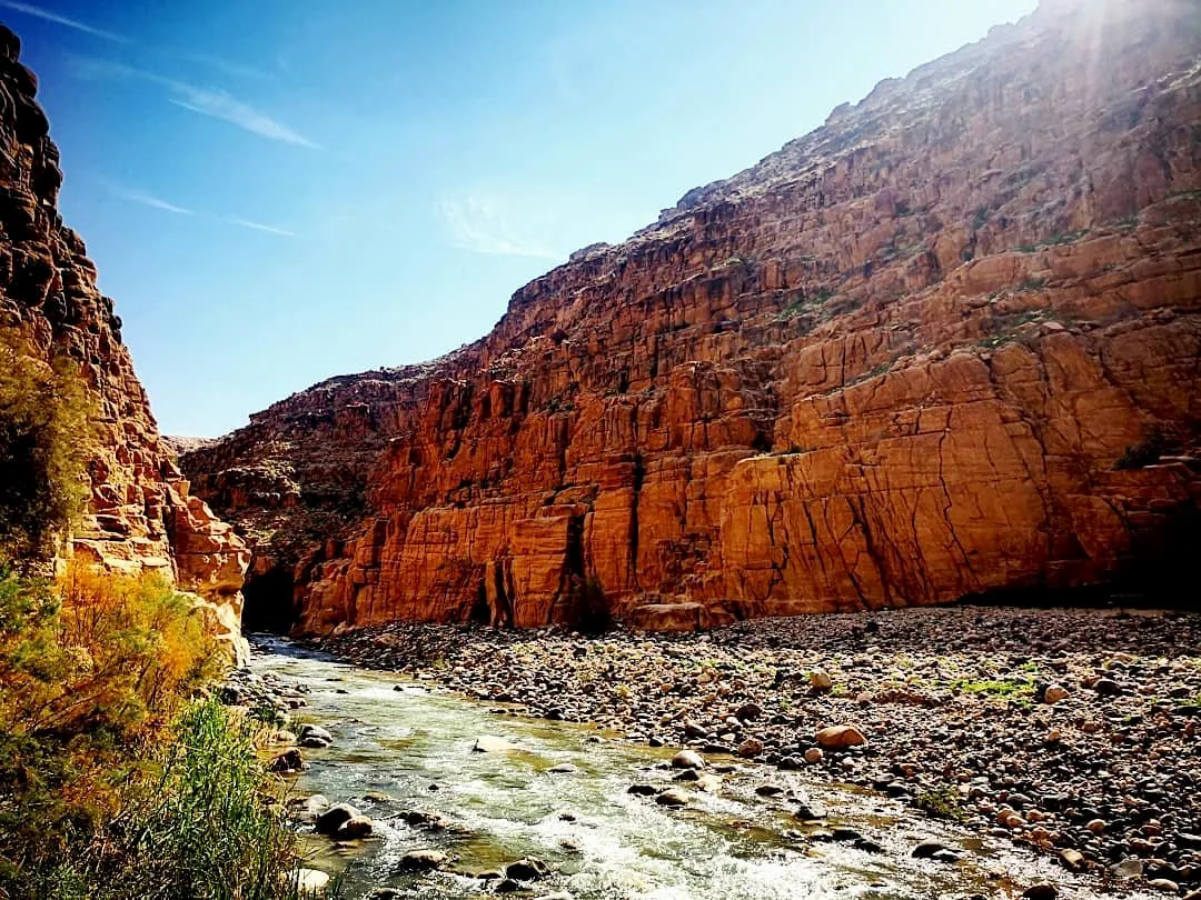 Wide sandstone canyon and shallow river landscape at Wadi Mujib in Jordan